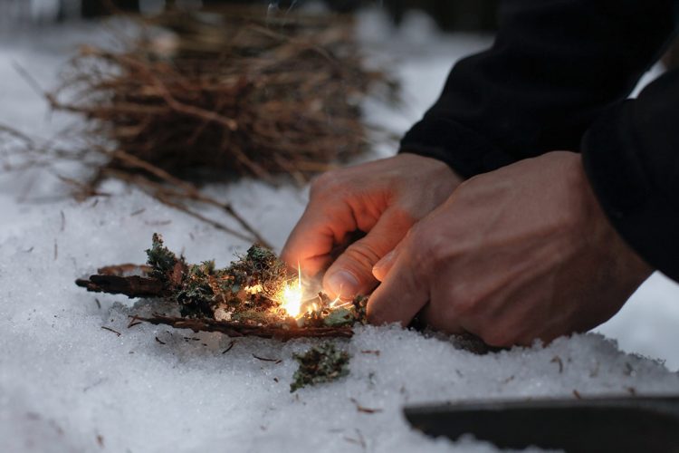 Close up of firelighting with kindling in the snow