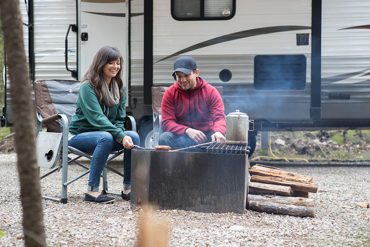 A couple cooking beside their RV while dry camping